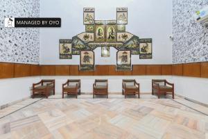 ein Zimmer mit Stühlen und einem Kreuz an der Wand in der Unterkunft FabHotel Classic Holidays in Jaipur