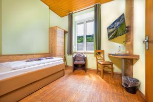 a room with a bed and a desk and a window at Altes Schulhaus in Zeltingen-Rachtig