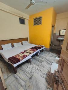 a bed in a room with a yellow wall at hotel aadarsh in Sendhwa