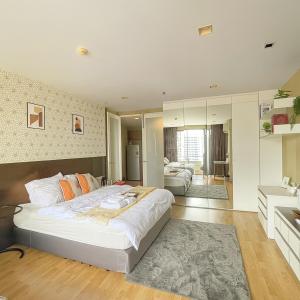 une chambre avec un grand lit blanc avec des oreillers orange dans l'établissement Modern 2 Bed Executive Unit - 5min to Nana BTS, à Bangkok 11 autres photos