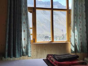 a bed in a room with a large window at Life inn Spiti in Kaza