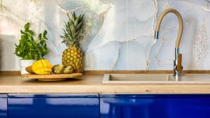 eine Ananas auf einer Theke neben einem Waschbecken in der Unterkunft Stegna Park II blisko morza Apartamenty Piamola in Stegna + 69 Fotos