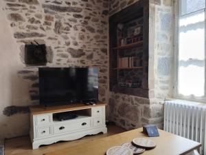 a living room with a television on a white cabinet at Spacious 3 bedroom house 250m from Saint-Suliac's beach in Saint-Suliac