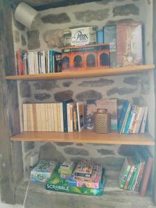 a book shelf filled with books on a stone wall at Spacious 3 bedroom house 250m from Saint-Suliac's beach in Saint-Suliac