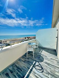 a table and a chair on a balcony with the beach at Hotel Continental in Tortoreto Lido