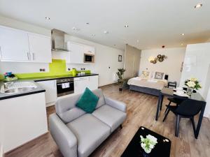 a living room with a couch and a kitchen with a bed at Fox House, Studio Apartments in Plymouth