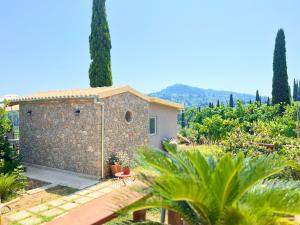 a small stone building in a garden with trees at Linda House Corfu in Gastouri