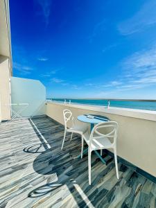 a patio with two chairs and a table on the beach at Hotel Continental in Tortoreto Lido