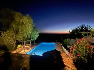 a swimming pool in a yard at night at Les 5 terrasses - vue imprenable et piscine privée in La Sauvetat