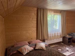 a bedroom with a bed in front of a window at Карпатський котедж Karpatian cottage in Vorokhta