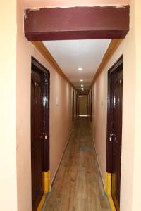 an empty hallway with two doors and wooden floors at Spot On V GUST IN in Tenāli