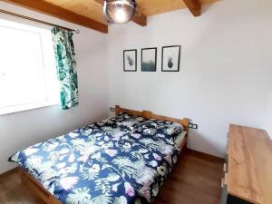 a bedroom with a bed with a blue and white blanket at Domek Urok Roztocza in Susiec