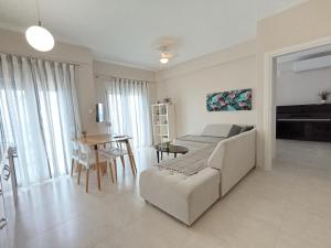 a living room with a couch and a table at Breeze - Cozy Beachfront Lux Apartment - Listen Piano & the waves in Flogita