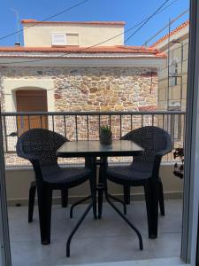 a table and two chairs on a balcony at Casa 3K in Chios