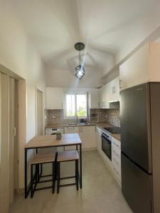 a kitchen with a wooden table and a black refrigerator at Casa 3K in Chios
