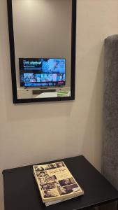 ジッダにあるشقة انيقة استديو بدخول ذاتيの壁にテレビとテーブルが置かれている写真 +7枚の写真