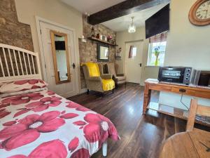 Schlafzimmer mit einem Bett und einem Schreibtisch mit einer Mikrowelle in der Unterkunft Bluebell Cottage in Armagh