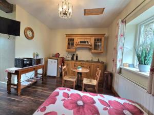eine Küche mit einem Bett und einem Tisch in einem Zimmer in der Unterkunft Bluebell Cottage in Armagh
