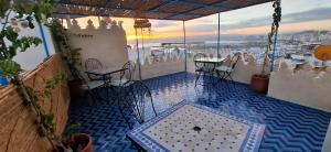 a patio with tables and chairs on a balcony at Riad chrifa in Tangier