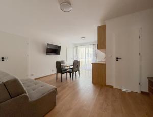 a living room with a couch and a table at Chatka Morska 3 Apartamenty in Karwia
