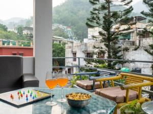 ein Tisch mit zwei Gläsern Wein auf einem Balkon in der Unterkunft Moustache Hostel Rishikesh in Rishikesh