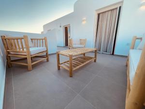two chairs and a bench in a living room at Theofanis Studios in Agia Anna Naxos