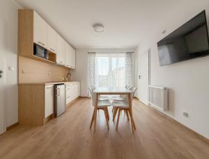a kitchen and dining room with a table and chairs at Chatka Morska 3 Apartamenty in Karwia +11 photos