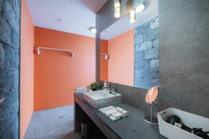 baño con lavabo y pared de color naranja en Mónaco House, en Ponta Delgada 23 fotos más
