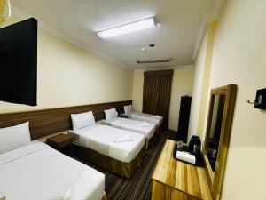 a hotel room with two beds and a flat screen tv at Diouf Al-Maqam Al-Dhahabi Hotel Free shuttle service to the Haram in Makkah