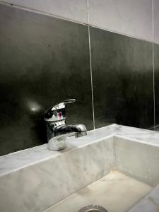 a bathroom sink with a faucet and a mirror at Riad Dar Chaafa 17 in Salé