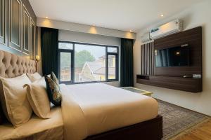 a bedroom with a large bed and a large window at De Elaaf The Luxury Stay in Srinagar