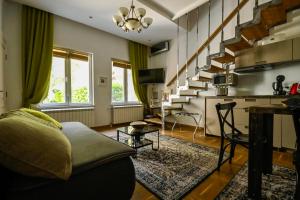 ein Wohnzimmer mit einer Couch und einer Treppe in der Unterkunft Green and Blue Garden Apartments in Belgrad