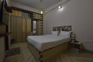 a bedroom with a large bed with white sheets at Hotel The Grand Kailash in Jaipur +55 photos