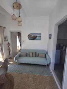 a living room with a blue couch in a room at Amphitrite in Hydra