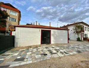 a white building with a red door and a building at ULAŞ TWENTY Rooms in Edirne