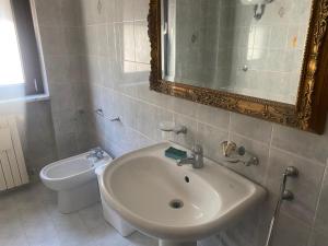 a bathroom with a sink and a toilet and a mirror at Da Caterina in Teramo
