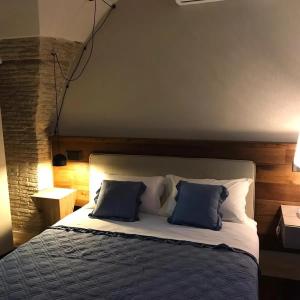 een slaapkamer met een bed met twee blauwe kussens bij Via Montecastello Emotional Room in Termoli