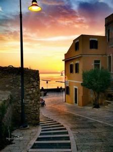 een straatlantaarn en een gebouw met een zonsondergang op de achtergrond bij Via Montecastello Emotional Room in Termoli
