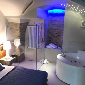 een slaapkamer met een bad en een bed en een kamer met een bed gmaxwell bij Via Montecastello Emotional Room in Termoli