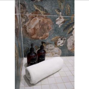 - une salle de bains avec 2 bouteilles de savon et une serviette dans l'établissement Central & Quiet, Full apart for 2 L'Escapade Fleurie, à Colmar 5 autres photos