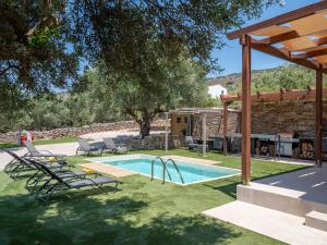 a backyard with a swimming pool and a house at Eleolithos Villa olive & pool in Fourní