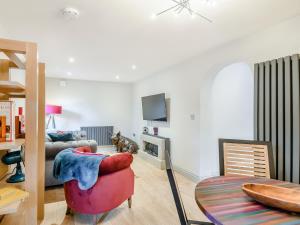 a living room with a red chair and a fireplace at Orchard Retreat in Kirton