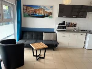 a living room with a couch and a table at Apartamenty Kormoran in Sarbinowo