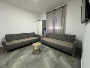 a living room with two couches and a table at Apartman 2 in Šušanj