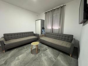 a living room with two couches and a table at Apartman 2 in Šušanj