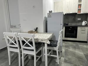 a kitchen with a table and chairs and a refrigerator at Apartman 2 in Šušanj +2 photos