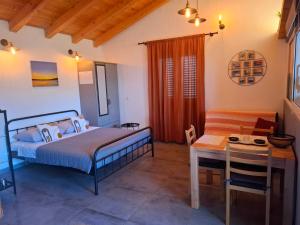 een slaapkamer met een bed en een tafel en een stoel bij Studio apartman Mediteran in Marina