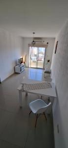 Sala de estar blanca con mesa y silla en ADS DEPARTAMENTOS 1, en La Plata