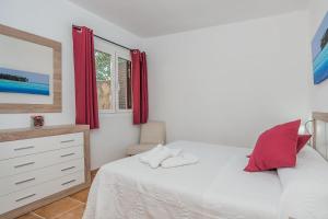 een slaapkamer met een bed, een ladekast en een raam bij La Rafal in Pollença +14 foto's