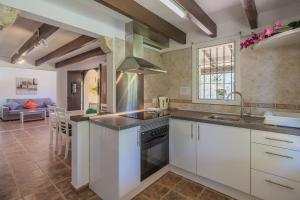 een keuken met witte kasten en een kookplaat oven bij La Rafal in Pollença